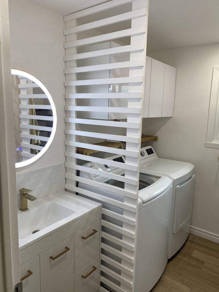 Une buanderie avec laveuse et sécheuse et un évier.