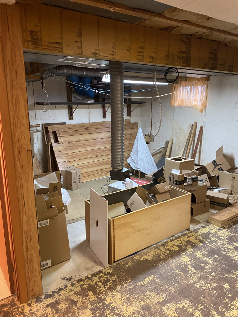 Une pièce remplie de beaucoup de boîtes et de bois.