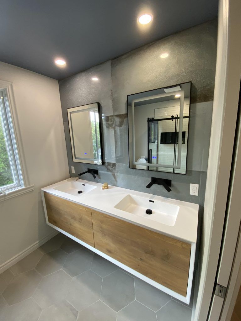 Une salle de bain avec deux lavabos et deux miroirs.