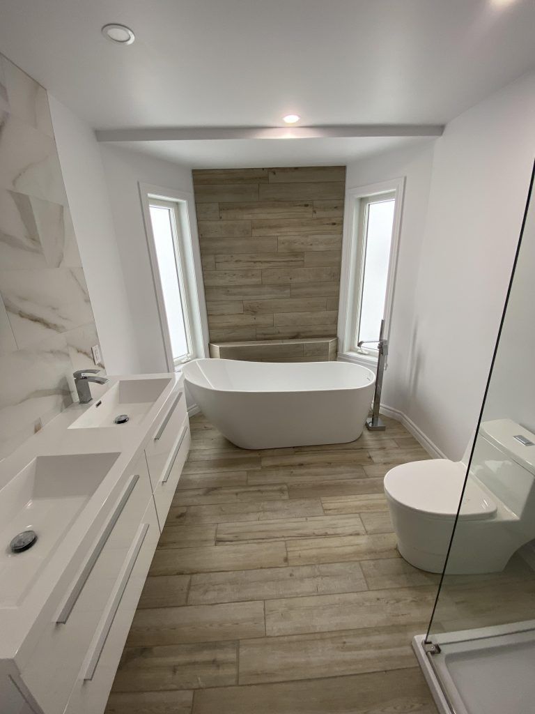 Une salle de bain avec baignoire, lavabo, WC et douche.