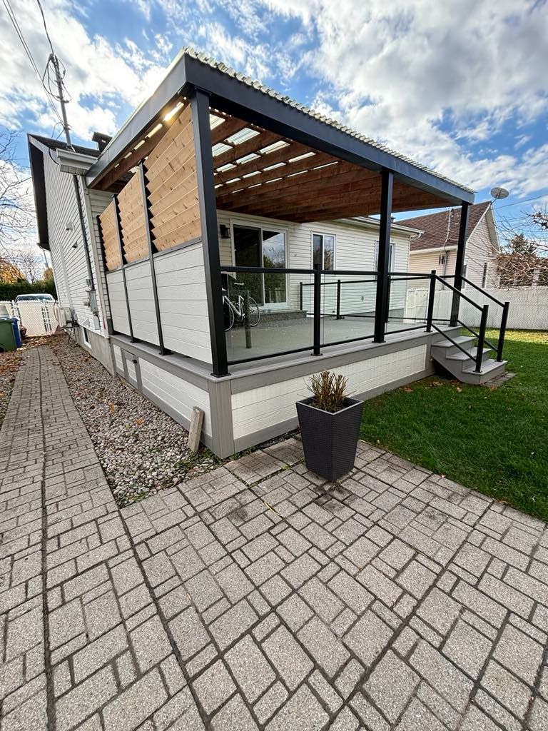 Une maison avec un porche et une plante en pot devant.