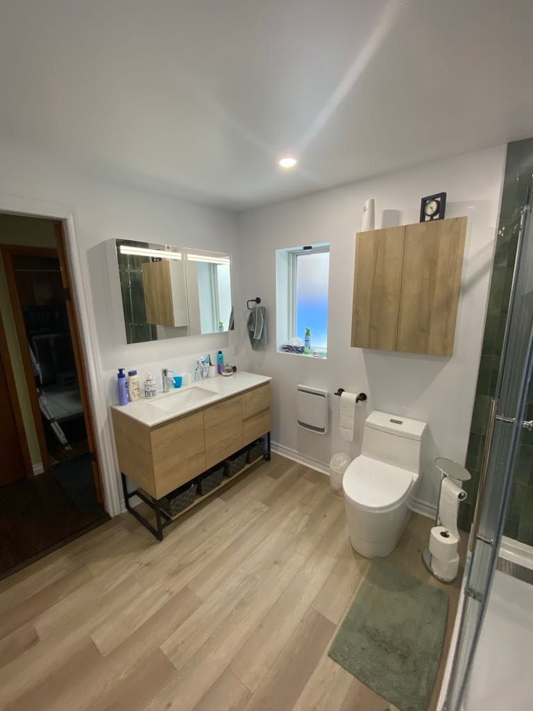 Une salle de bain avec WC, lavabo et miroir.