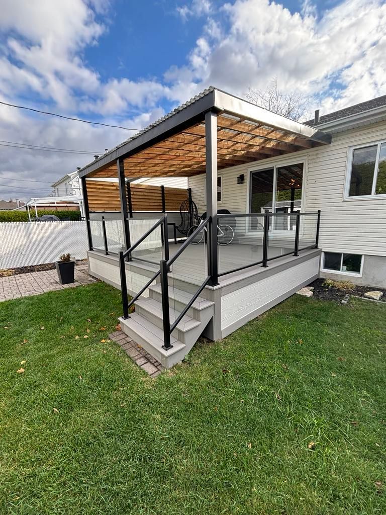 Une grande terrasse avec une pergola et des escaliers se trouve dans l'arrière-cour d'une maison.