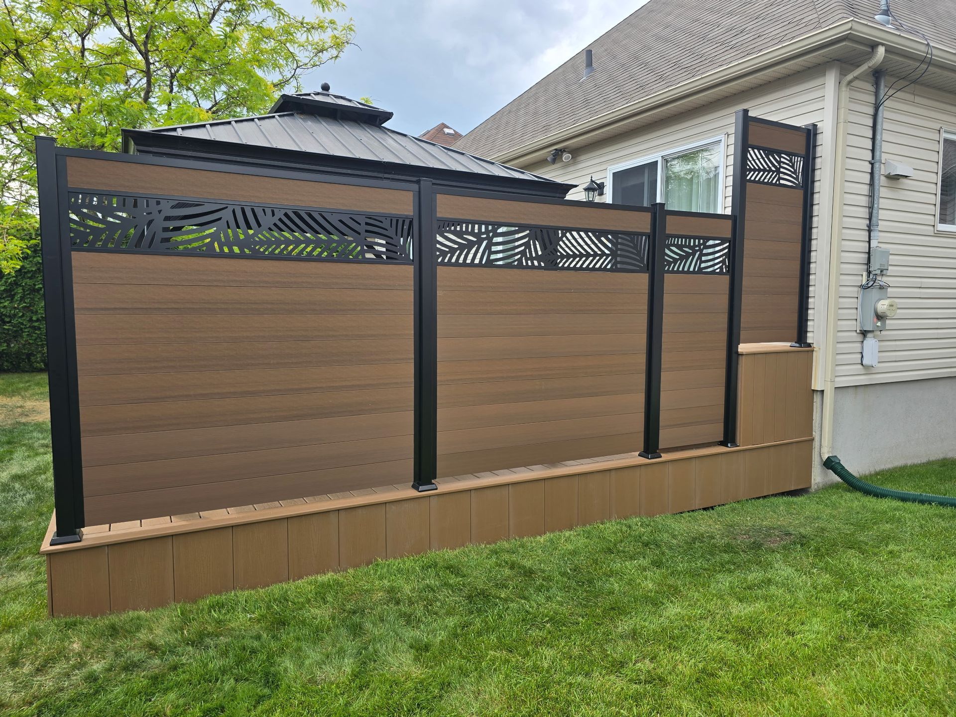 Une clôture en bois se trouve dans l'arrière-cour d'une maison.