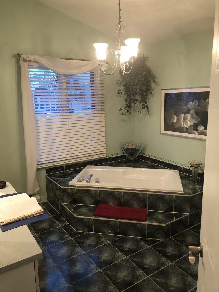 Une salle de bain avec une baignoire jacuzzi et un tableau au mur.