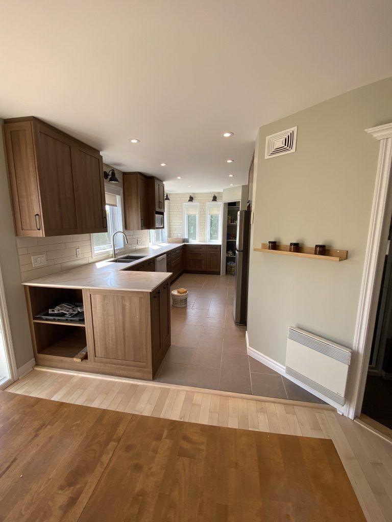 Une cuisine avec des armoires en bois et un plancher en bois.