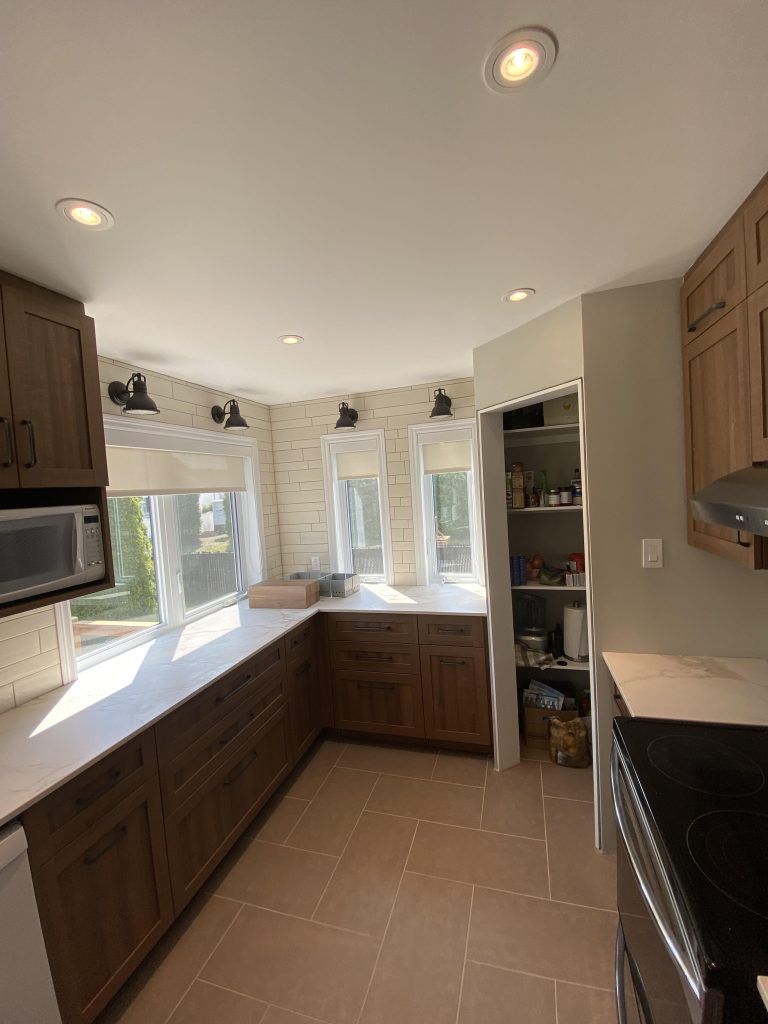 Une cuisine avec des armoires en bois, une cuisinière, un micro-ondes et un garde-manger.