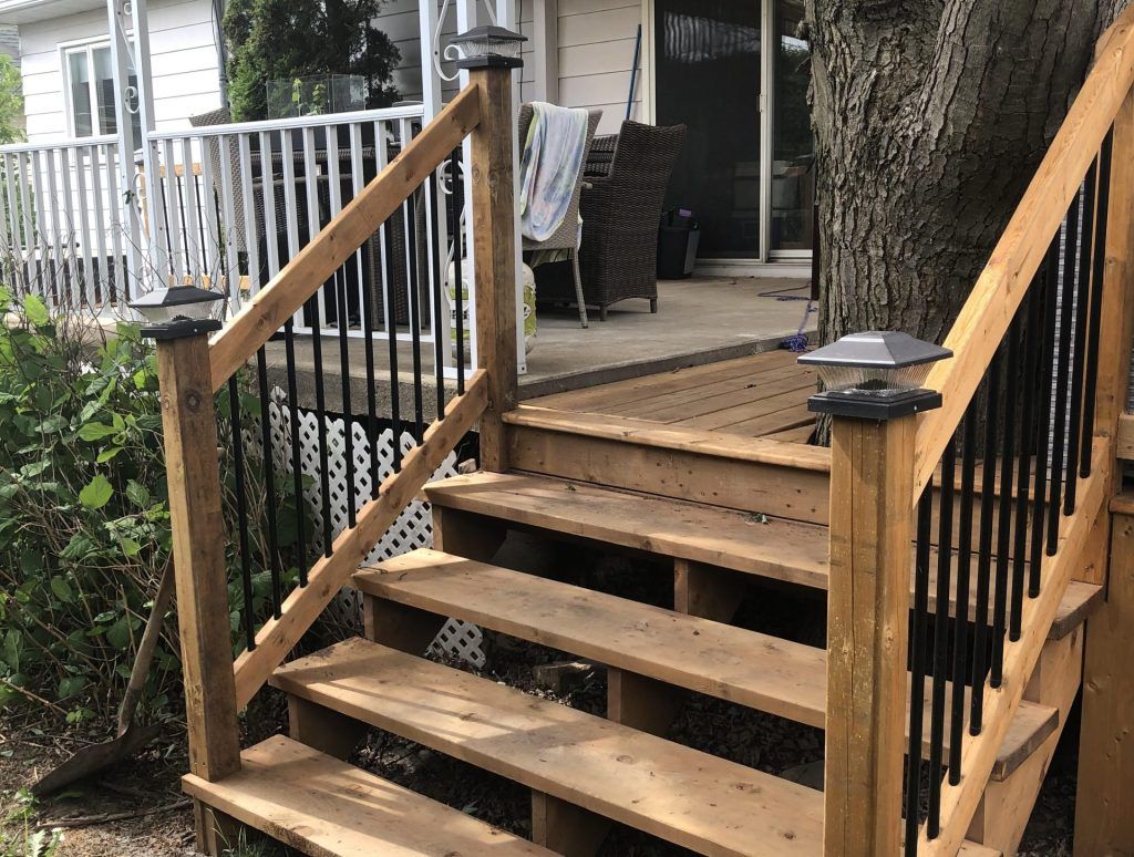 Une terrasse en bois avec des escaliers menant à une maison.