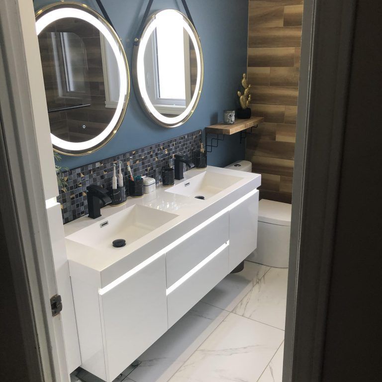 Une salle de bain avec deux lavabos et deux miroirs