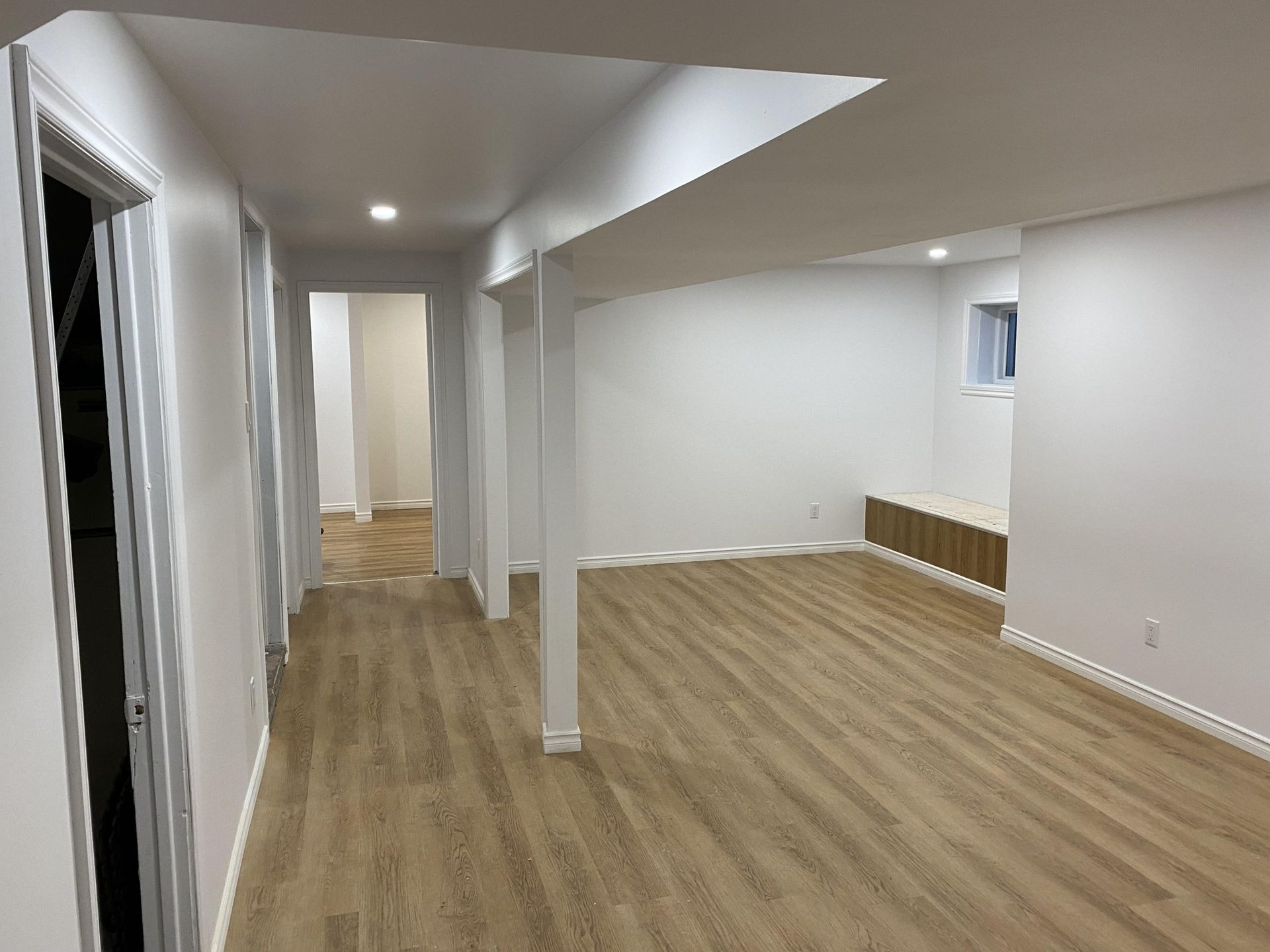 Un sous-sol vide avec du parquet et des murs blancs