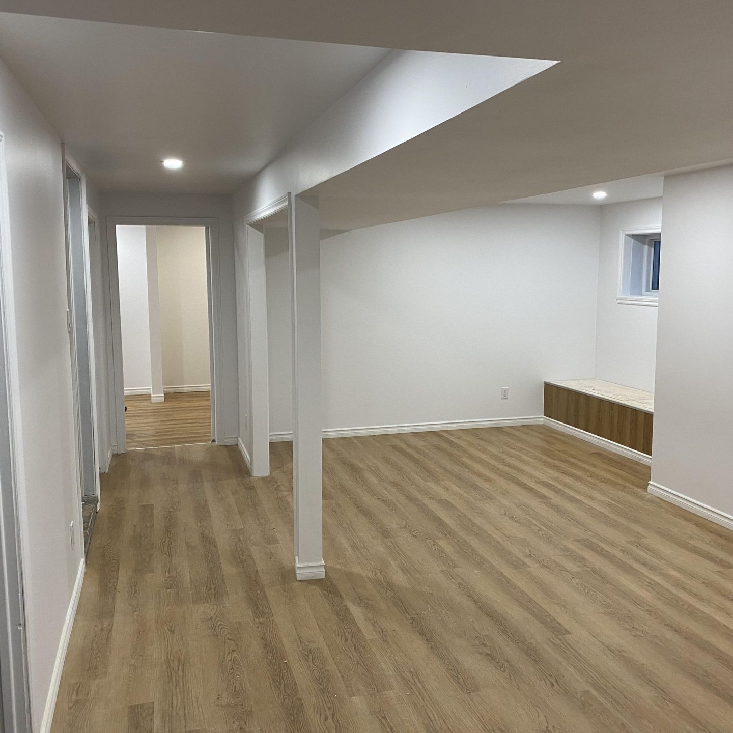 Un sous-sol vide avec du parquet et des murs blancs