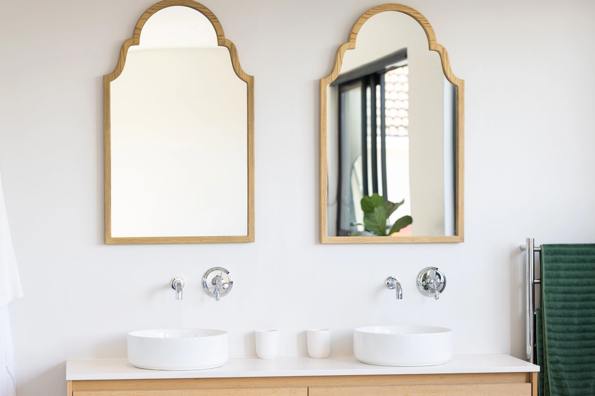 Un baño con dos lavabos y dos espejos en la pared.