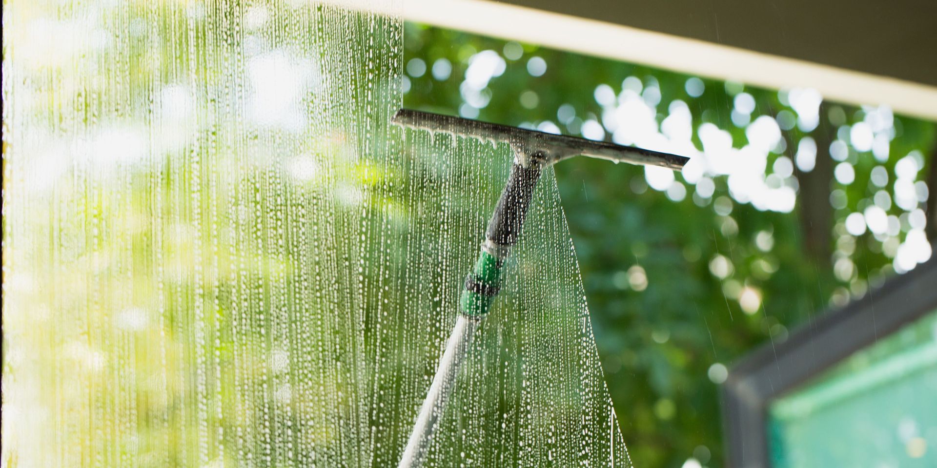 A person is cleaning a window with a squeegee.