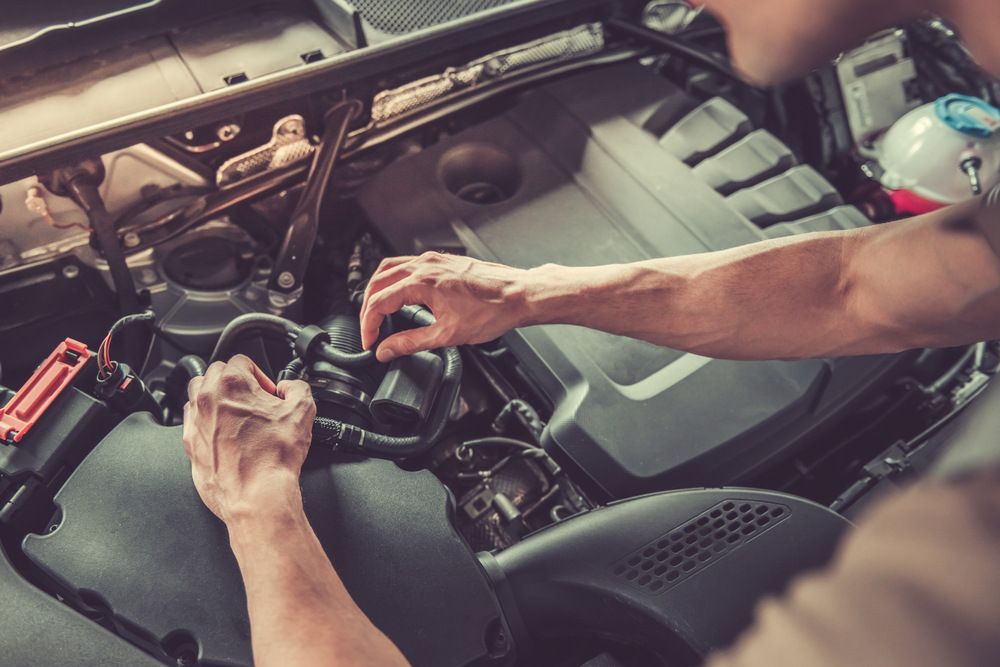 A Man Is Working On The Engine Of A Car — JA Toft & Co In Bundaberg Central, QLD
