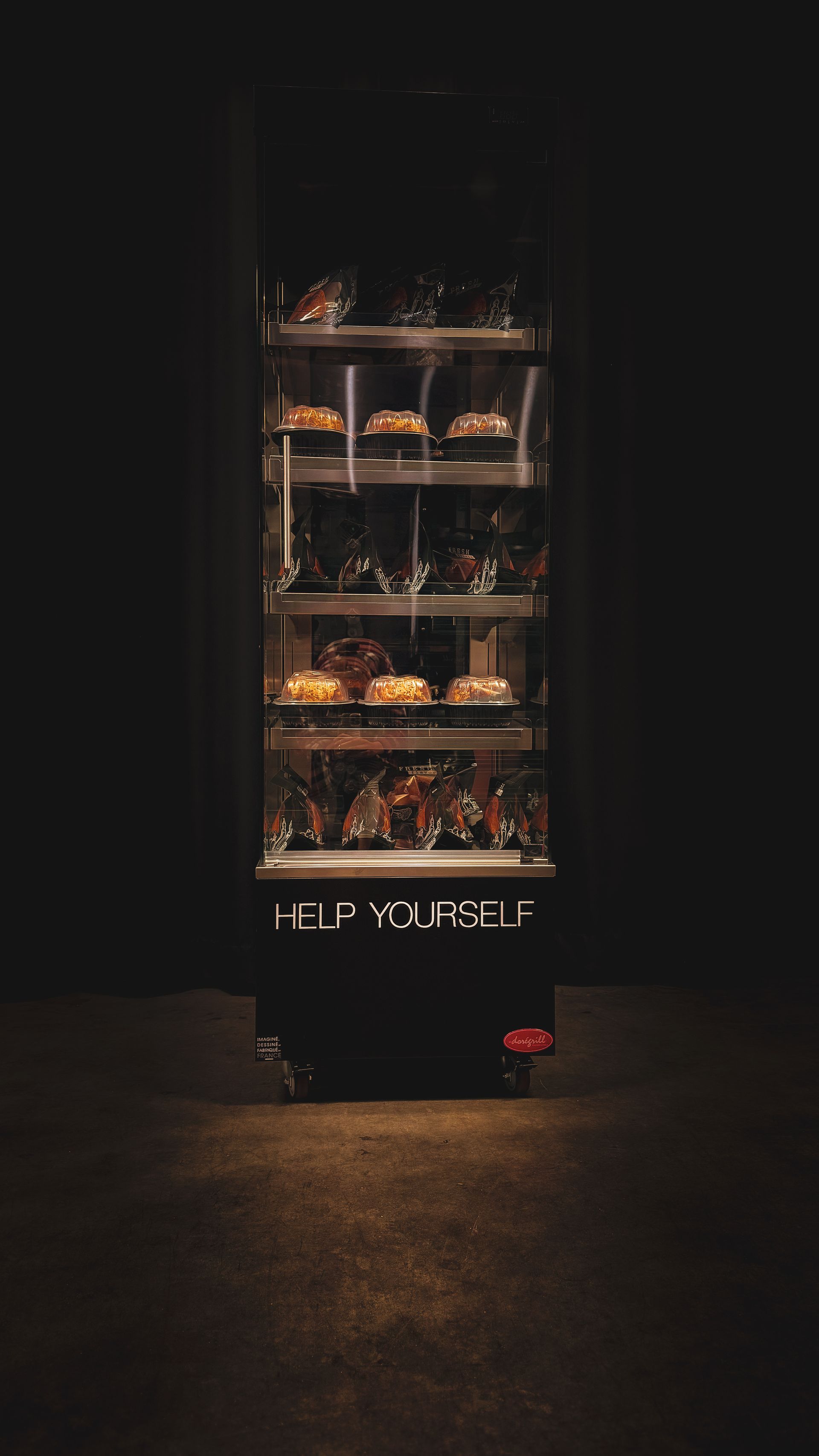 A vending machine filled with food in a dark room.