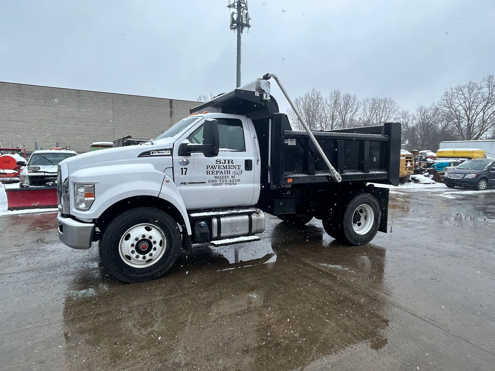 White dump truck in snowy lot.