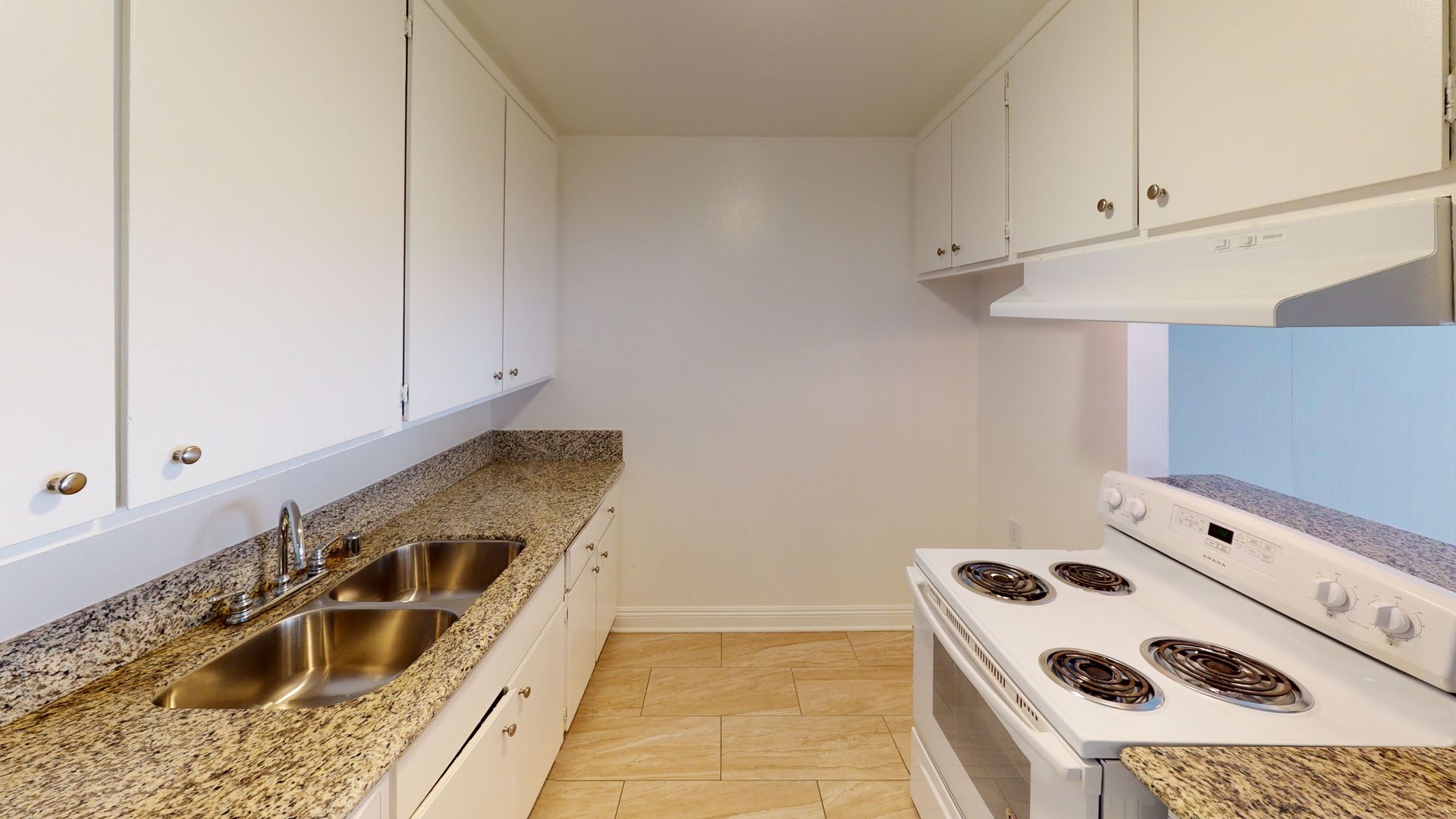 Kitchen with white cabinets, granite countertops, and a white stove.