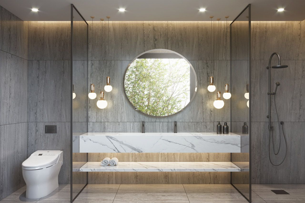 Modernes Badezimmer mit Marmorwaschtisch, rundem Spiegel und Glasduschtüren.