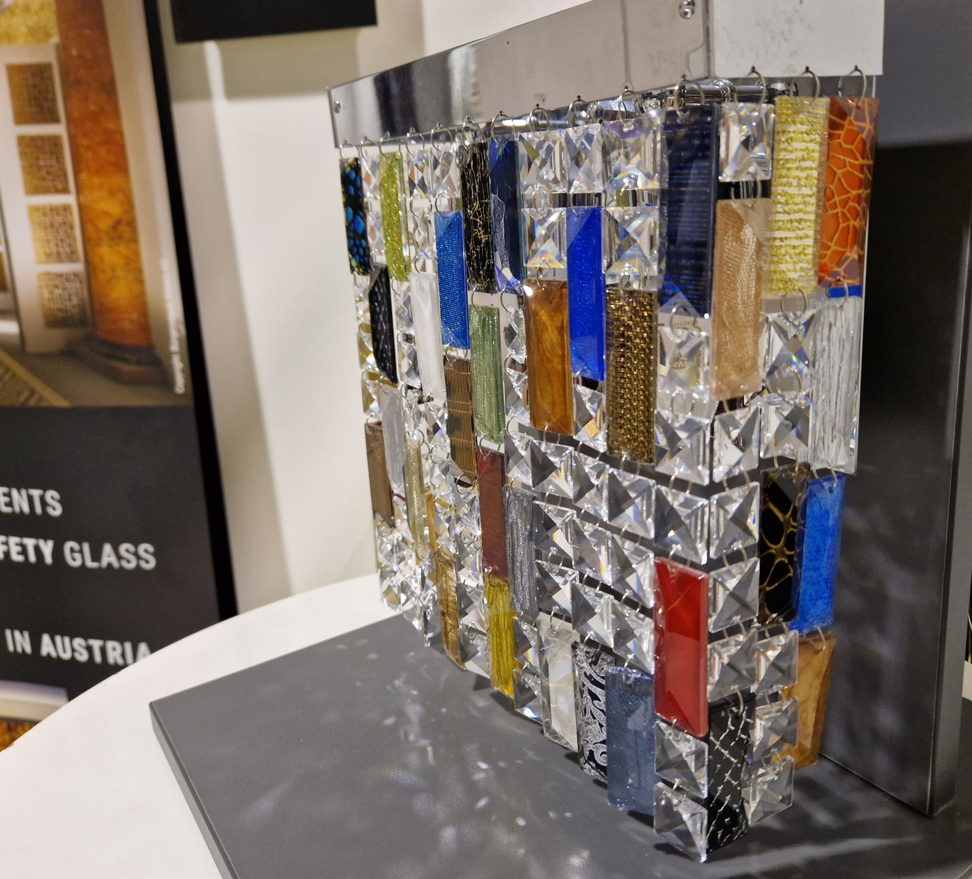 Eine dekorative Glasvitrine mit verschiedenen bunten rechteckigen Glasstücken, die in klare Glasquadrate eingefasst sind.