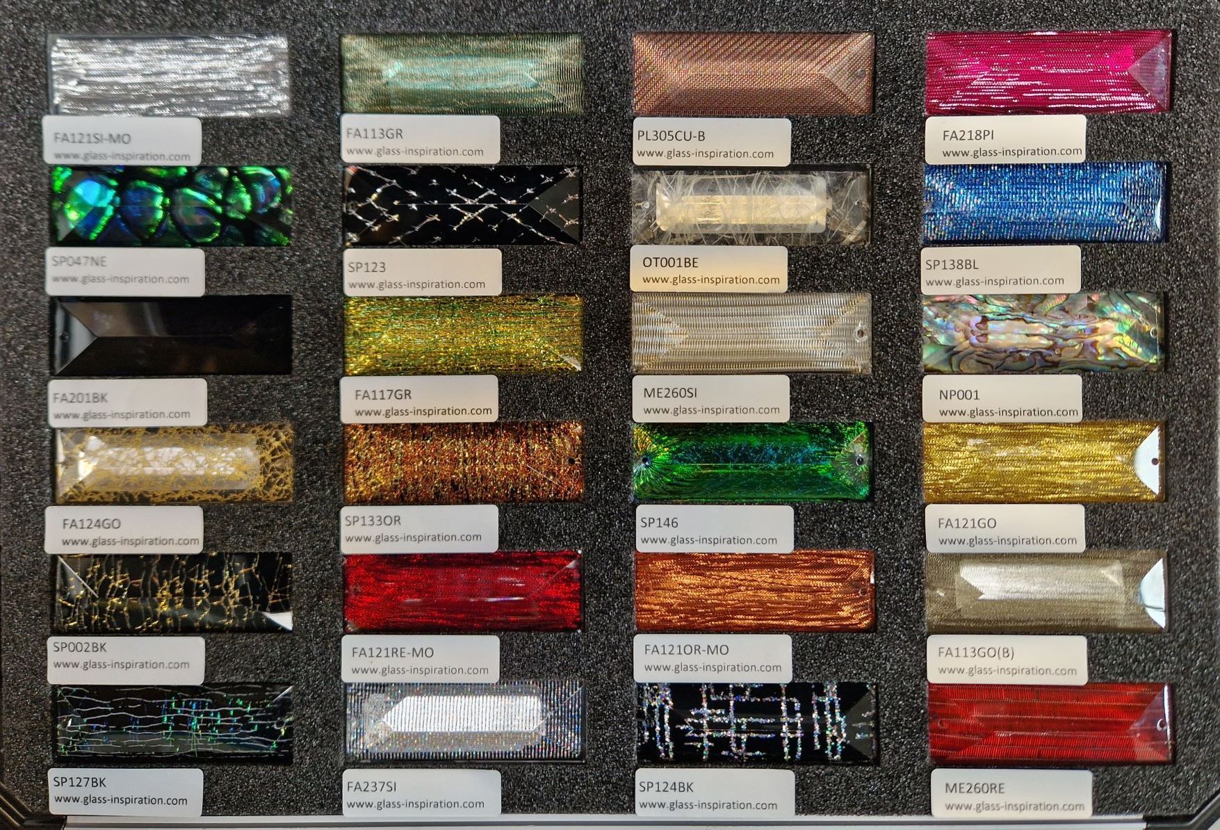 Ein Tablett mit rechteckigen Glasfliesenmustern in verschiedenen Farben und Texturen.