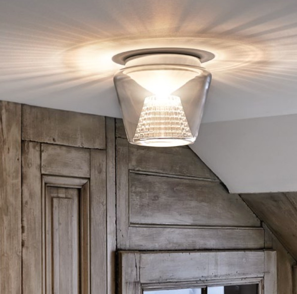 Deckenleuchte mit Glasschirm, montiert an einer holzgetäfelten Decke.