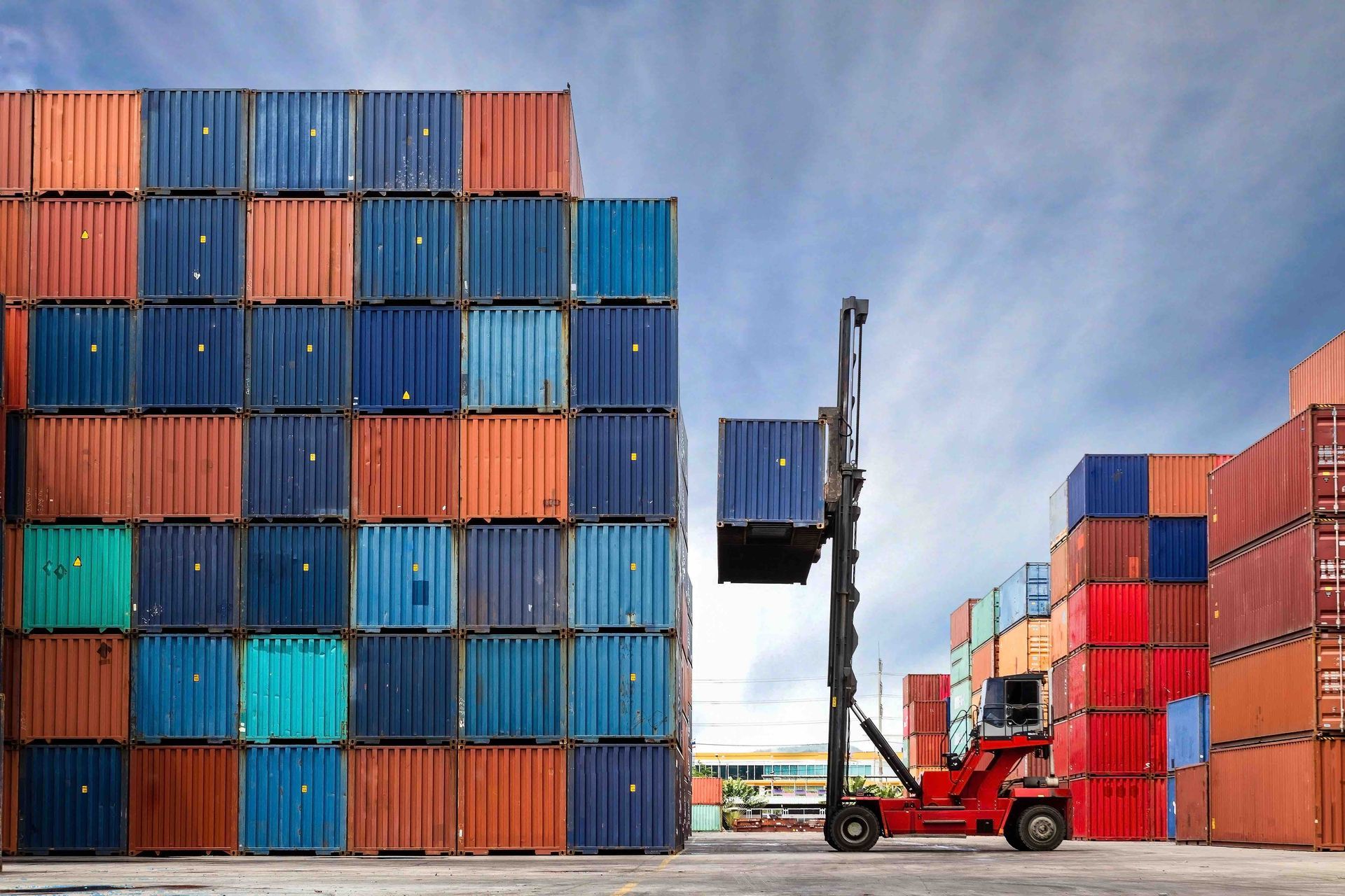A forklift is loading a container into a stack of containers.