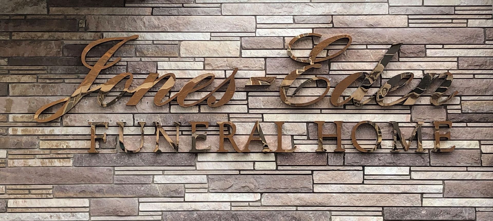 The front door of a house with a porch and plants in front of it.