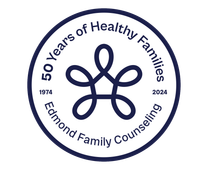 The logo for edmond family counseling shows a flower in a circle.