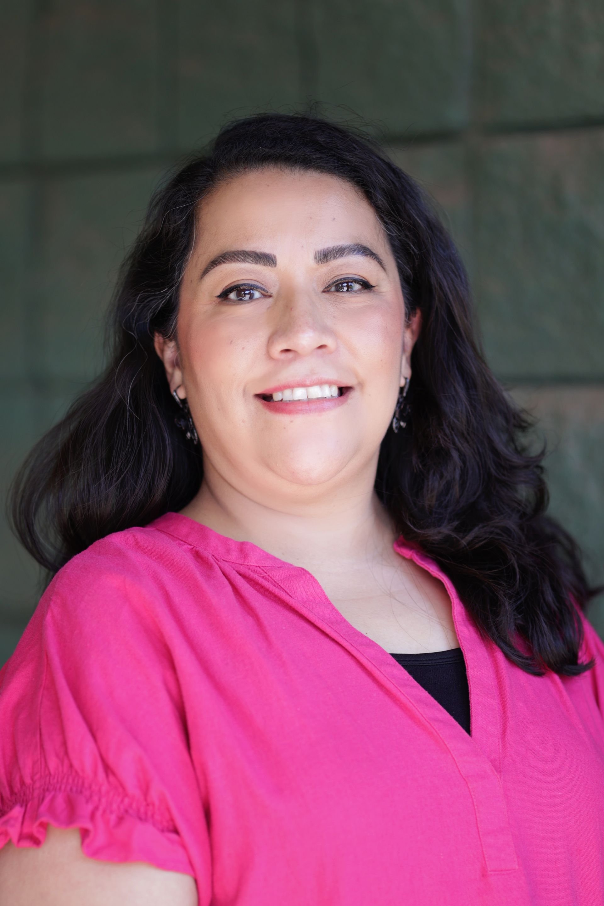A woman in a floral dress is smiling for the camera.