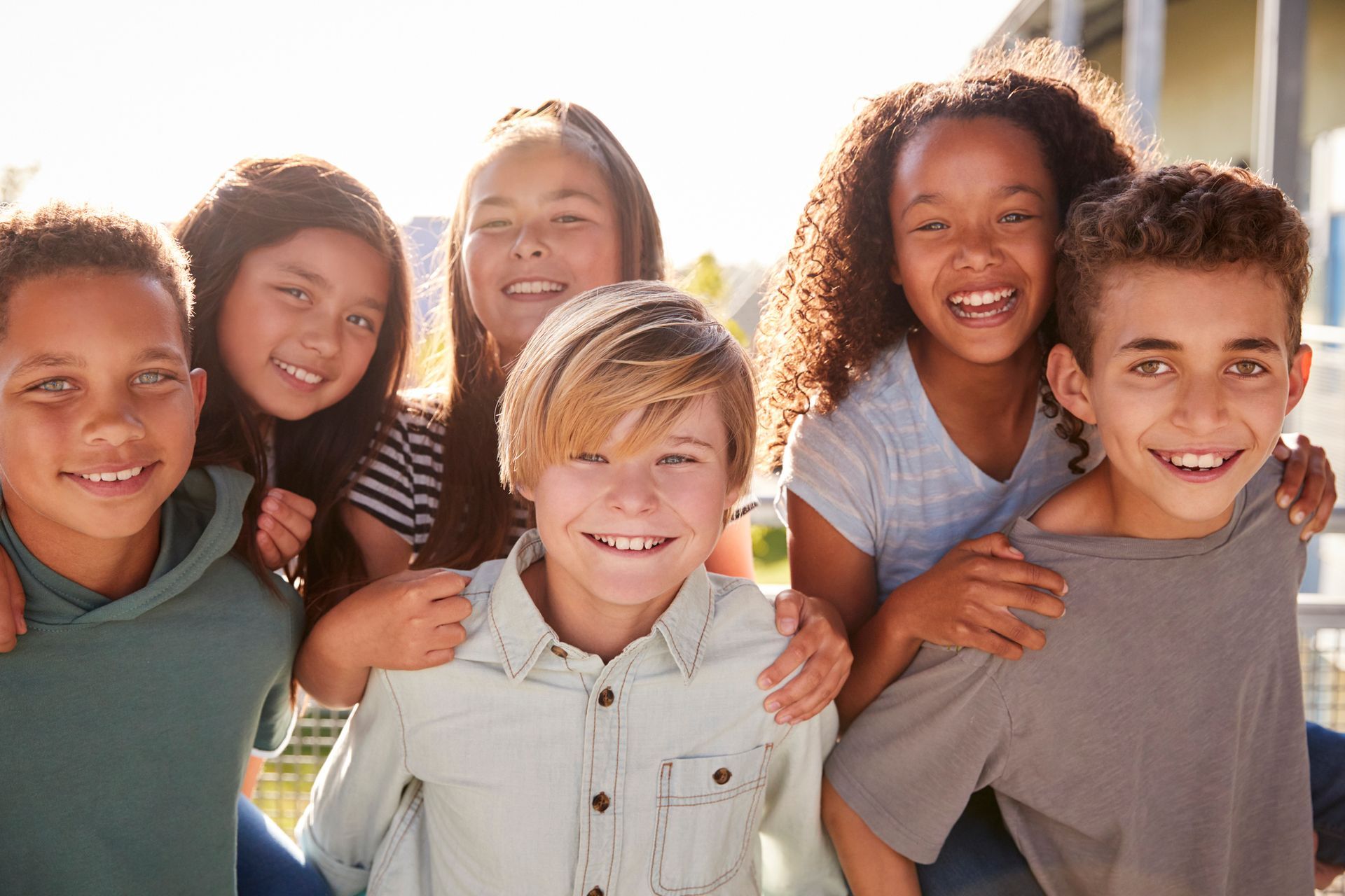A group of children are posing for a picture together and smiling.