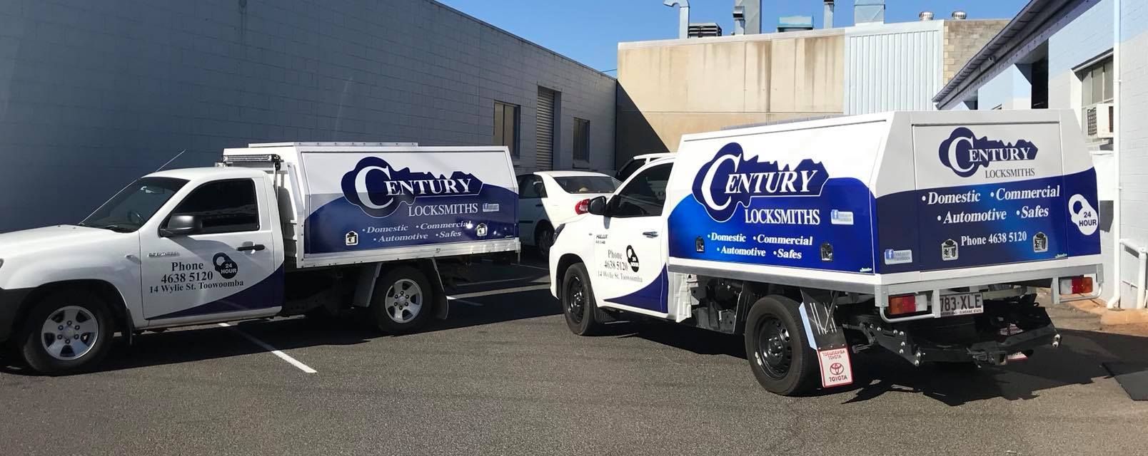 Two White Trucks With Blue Logos Parked by a Building — Century Locksmiths in Clifton, QLD