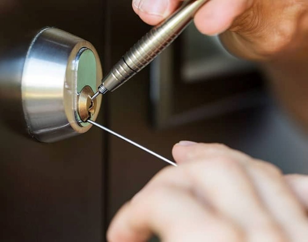A Person Is Using a Pen to Open a Door Lock — Century Locksmiths In Toowoomba City, QLD