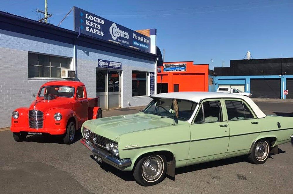 Two Old Cars Are Parked in Front of A Building — Century Locksmiths In Toowoomba City, QLD