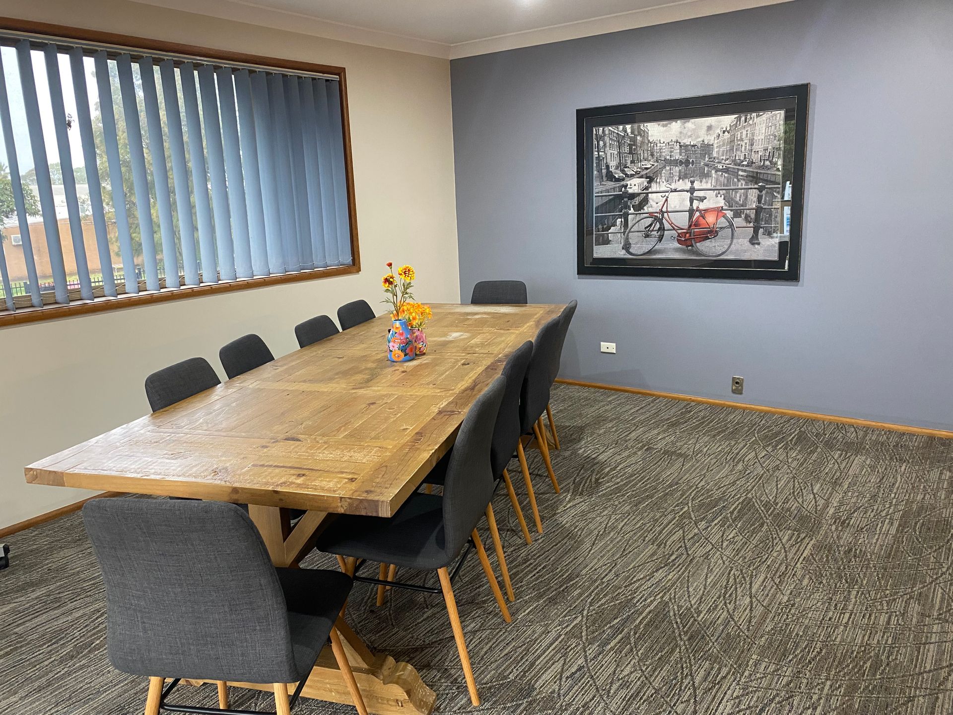 A woman and two children are playing with wooden blocks at a table.