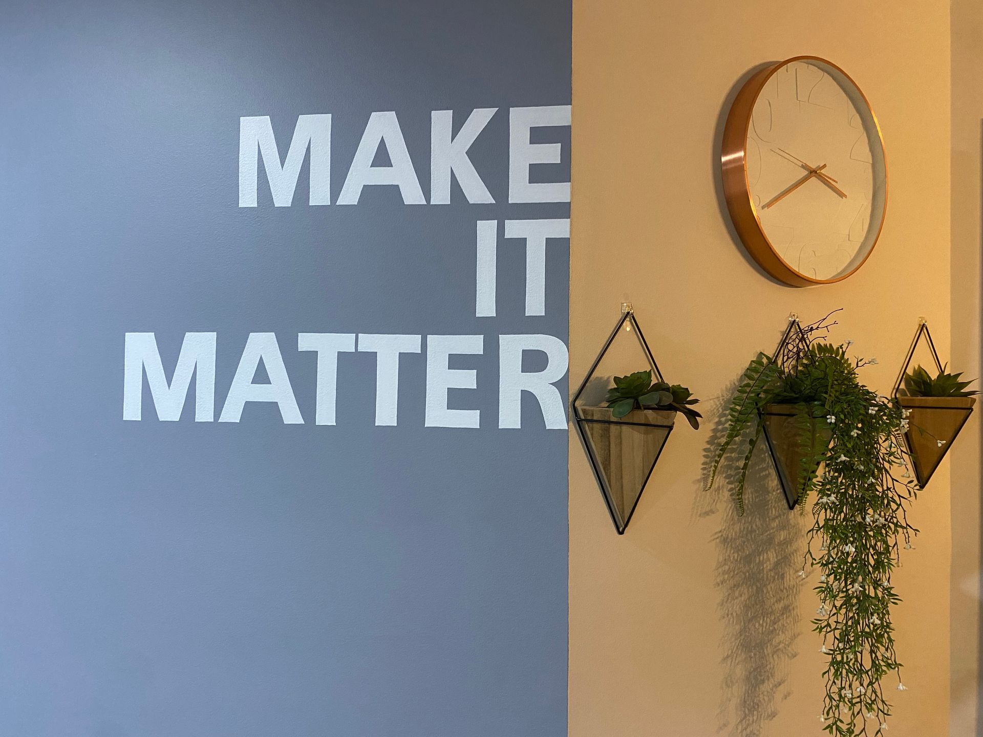 A woman and a child are jumping on a trampoline in a room.