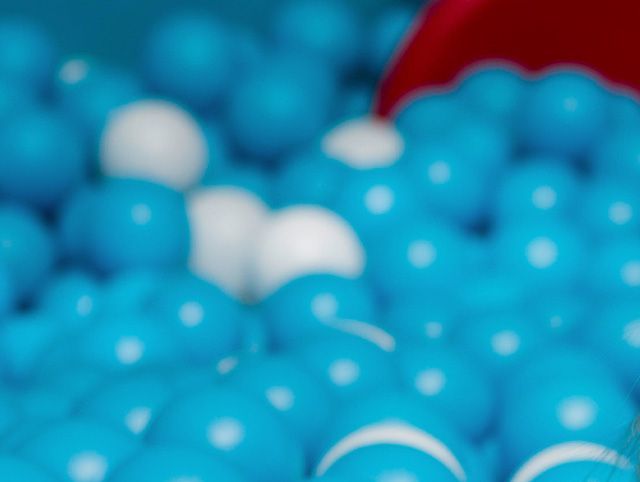 Een stapel blauw-witte stippenballen in een ballenbak.