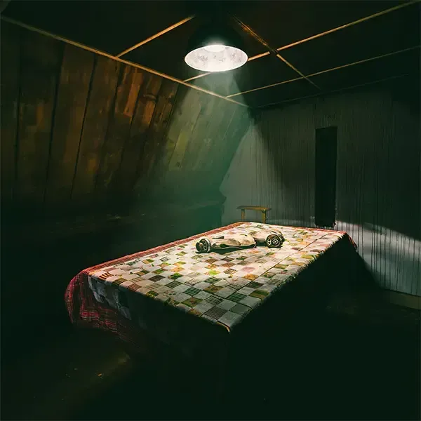 Een tafel in een donkere kamer met een licht dat door het plafond schijnt.