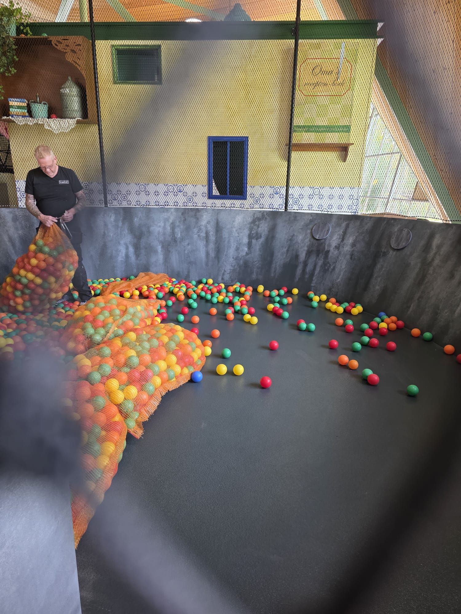 Een stapel blauw-witte stippenballen in een ballenbak.