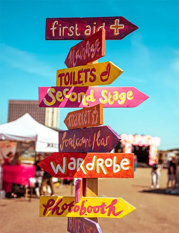 Een stapel borden die in verschillende richtingen wijzen, waaronder EHBO-toiletten en tweede trap