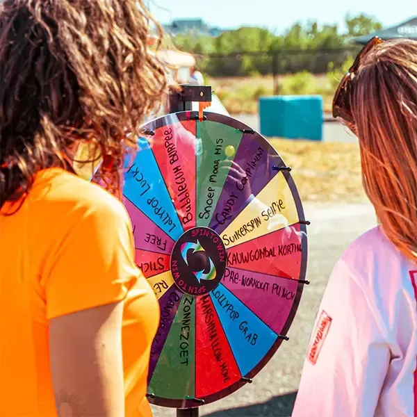 Twee meisjes kijken naar een kleurrijk spinnewiel