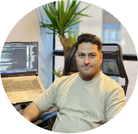A man is sitting in a chair in front of a laptop computer.