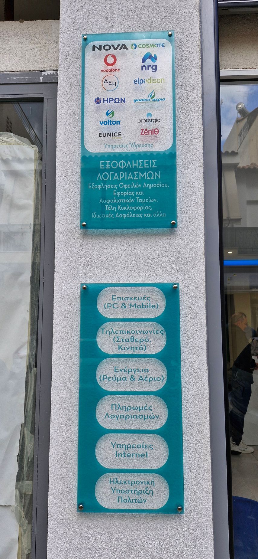 Πινακίδα με λογότυπα εταιρειών και υπηρεσίες που αναφέρονται σε έναν ανάγλυφο τοίχο.