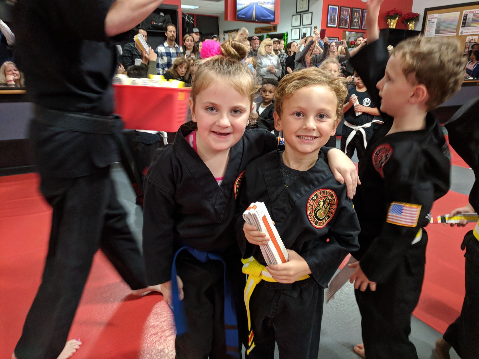 A group of children in karate uniforms pose for a picture