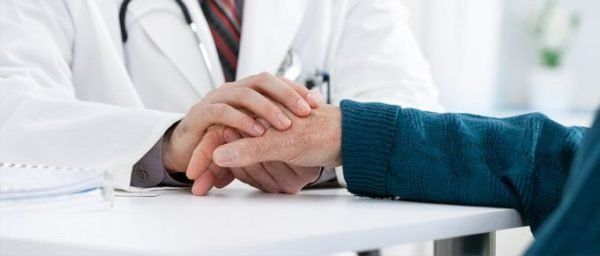 doctor holds a patient's hand