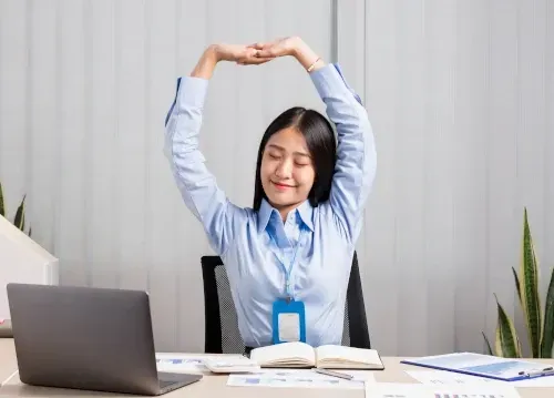 female stretching at her desk
