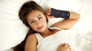 Young caucasian brunette woman sleeping with a night brace.