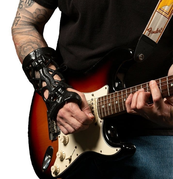 Man wearing a wrist brace while playing guitar.