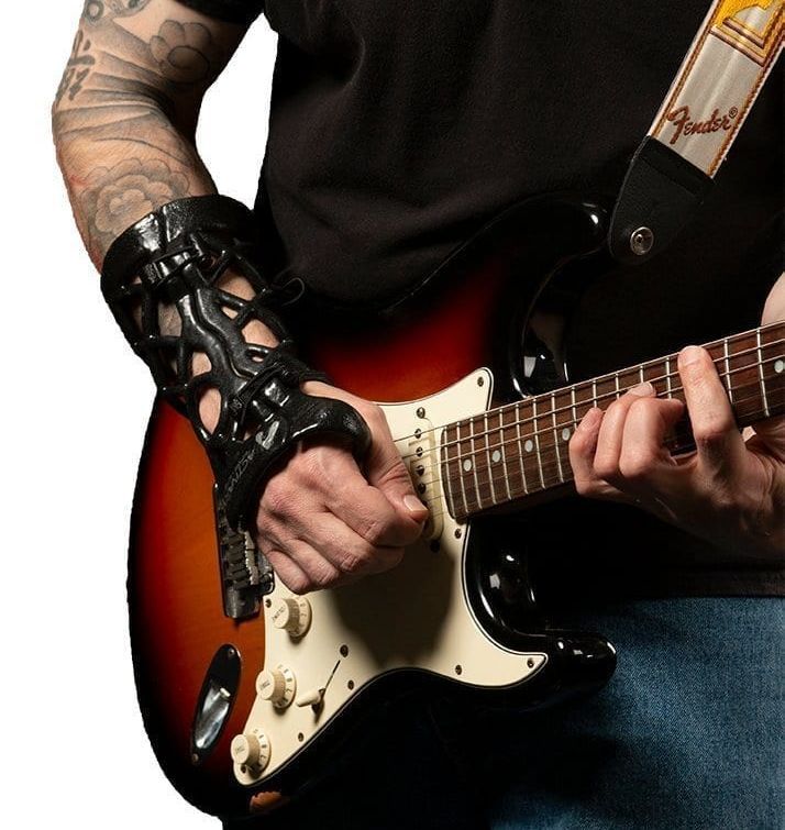 Man wearing a wrist brace while playing guitar.