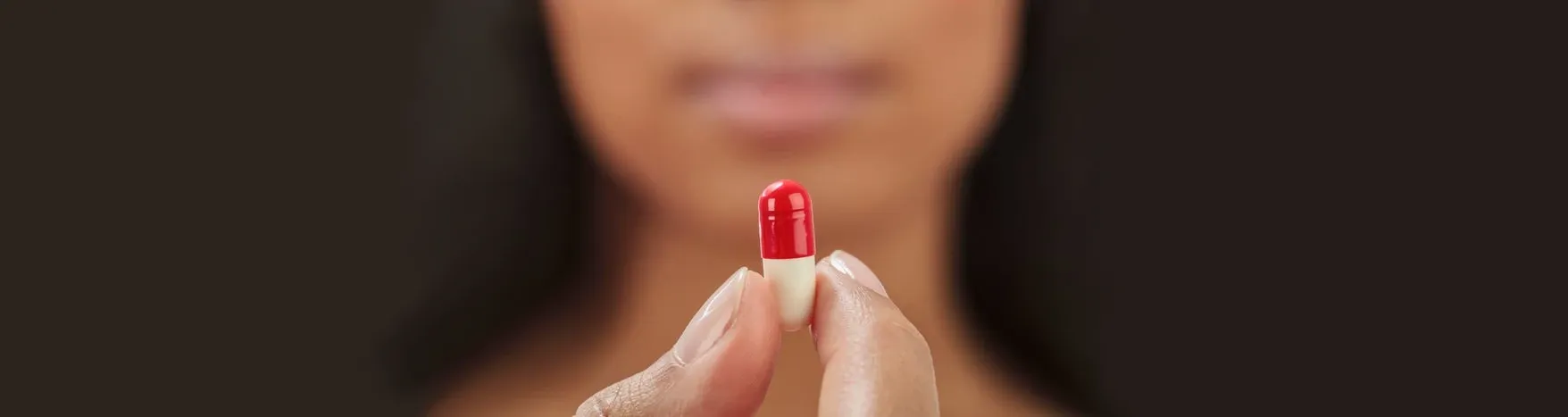 person taking a vitamin supplement