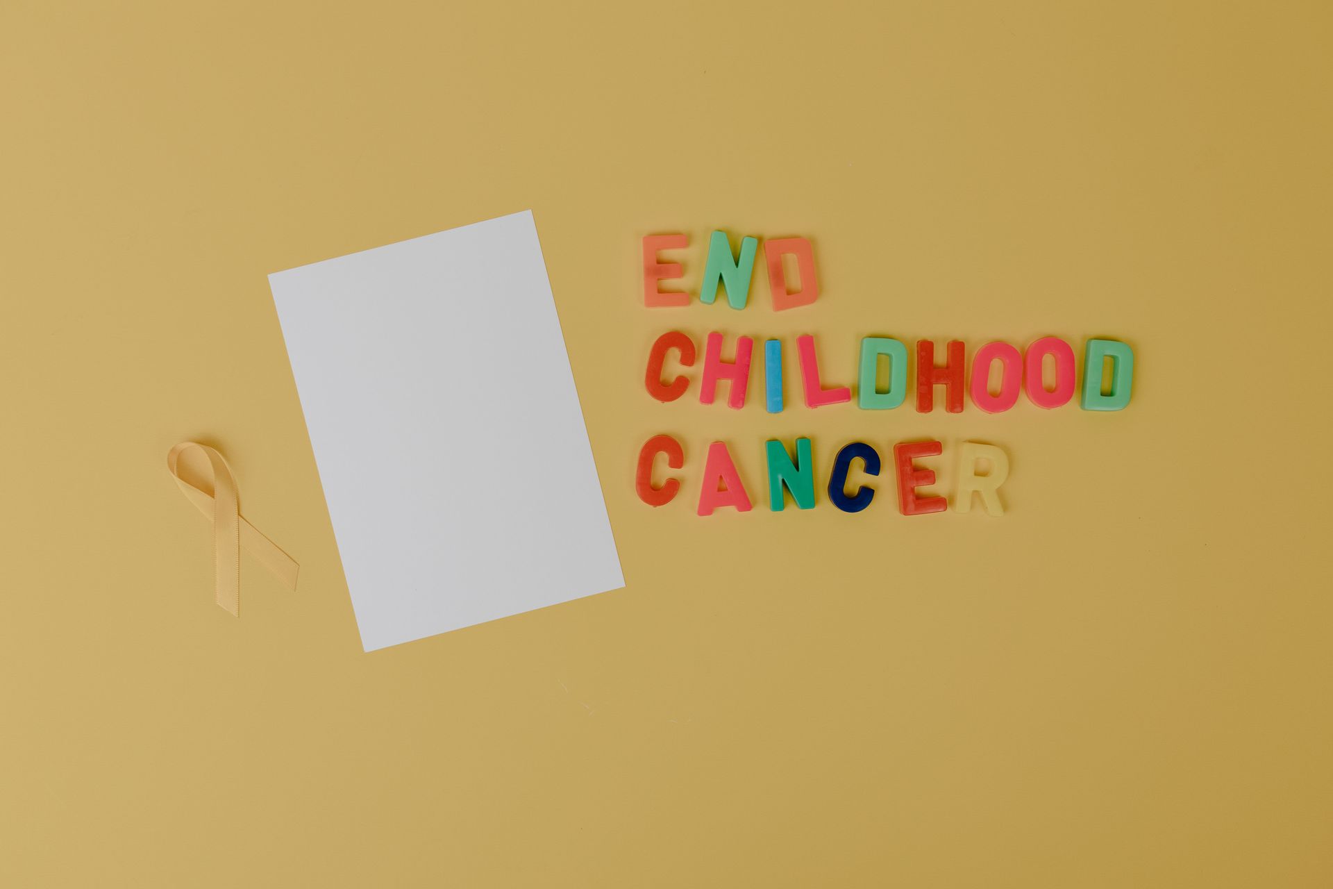 Yellow background with a blank white card and colorful “END CHILDHOOD CANCER” text